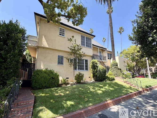 A house with a red brick walkway in front of it.
