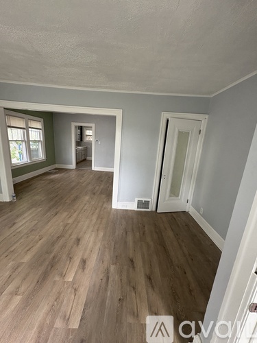 A room with wooden flooring and white walls.