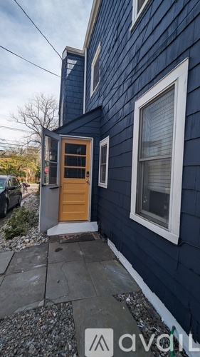 A blue house with a wooden door and a window.