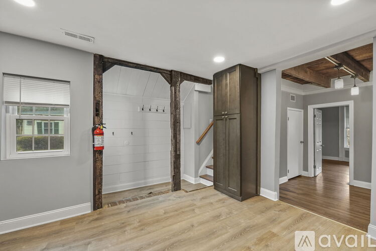 A room with wooden floors and a large wooden beam in the center.