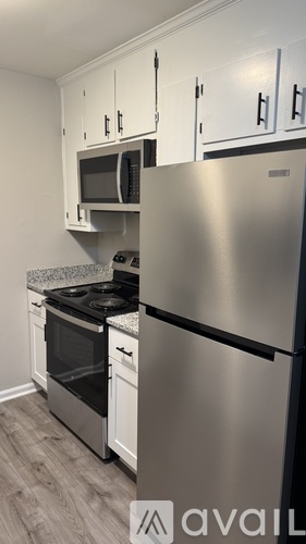 A kitchen with a stainless steel refrigerator, microwave, oven, and cabinets.