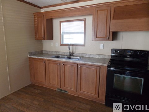 A kitchen with wooden cabinets and a black oven.