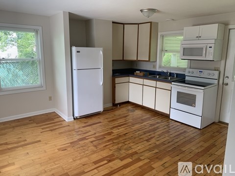 A kitchen with wooden floors and white appliances.