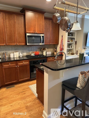 A kitchen with wooden cabinets and a black countertop.