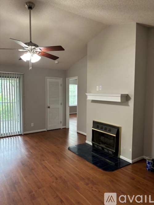 A living room with a fireplace and a ceiling fan.
