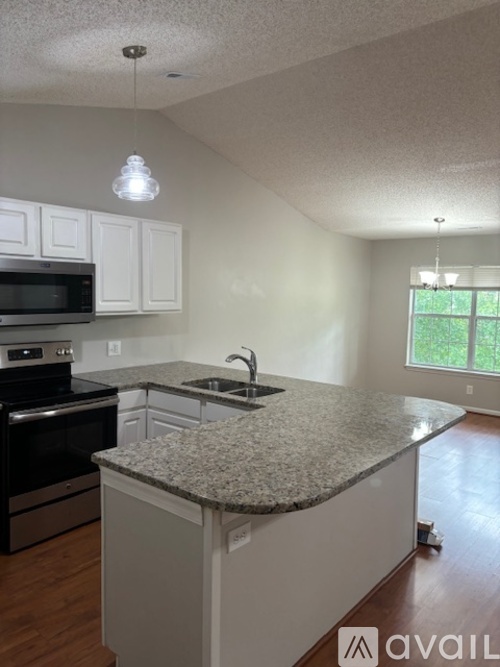 A kitchen with granite countertops and white cabinets.
