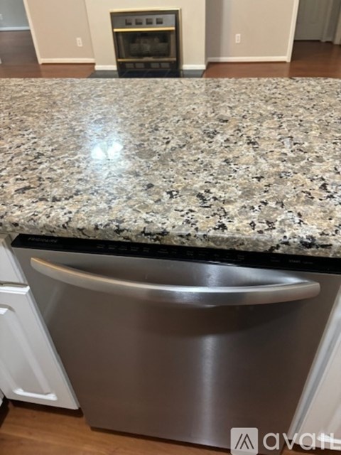A kitchen counter with a granite top and a stainless steel dishwasher.