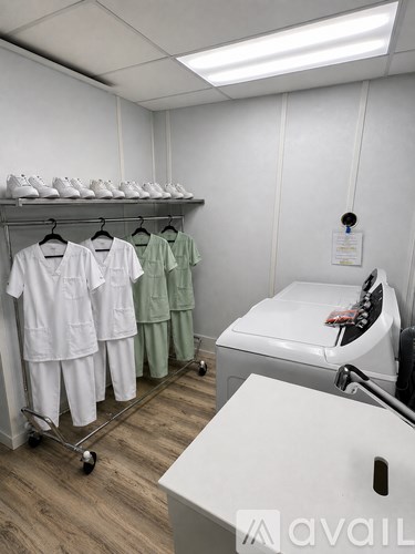 A white room with a shelf of shoes and clothes on racks.