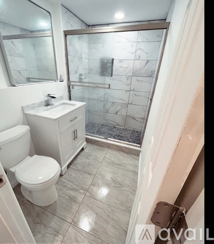 A bathroom with a toilet, sink, and walk-in shower.