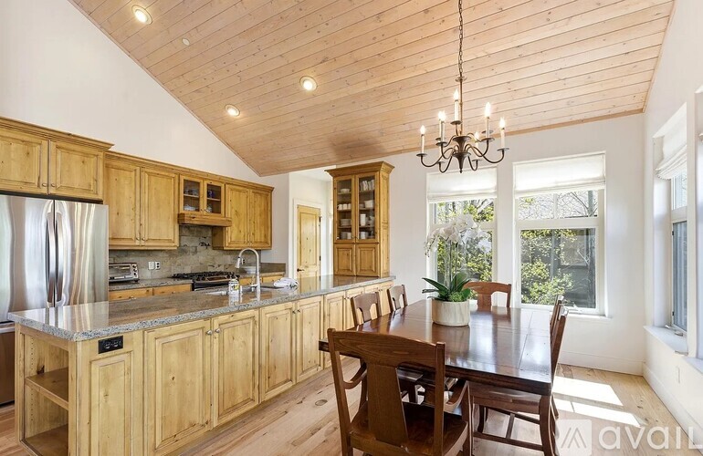 A kitchen with wooden cabinets and a dining table.