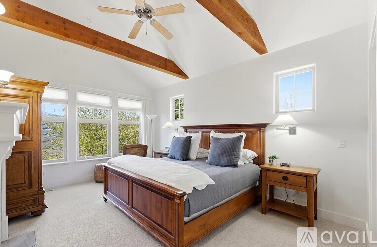 A bedroom with a large bed and a ceiling fan.