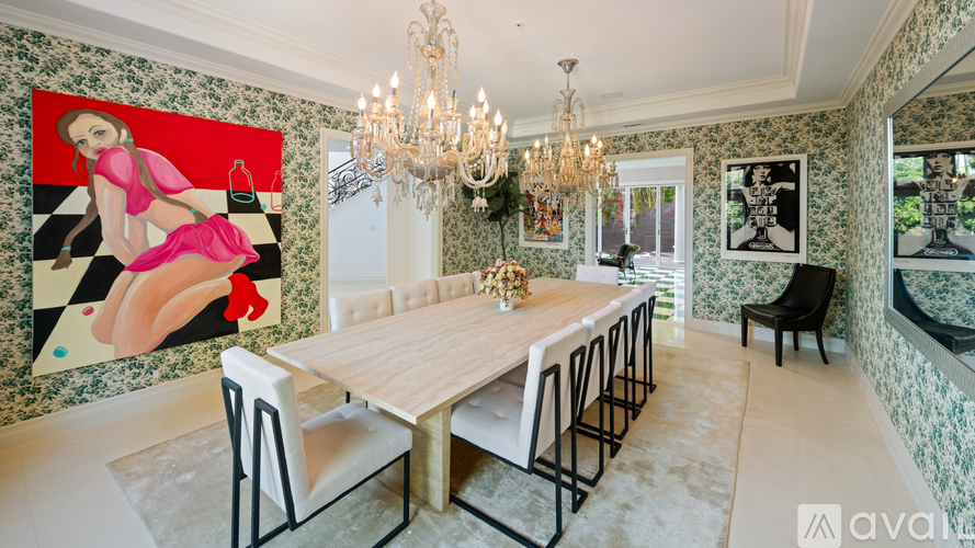 A dining room with a chandelier, a table with chairs, and a wall with a picture of a woman.