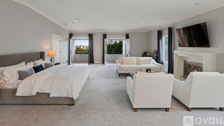 A spacious bedroom with a large bed and a fireplace.