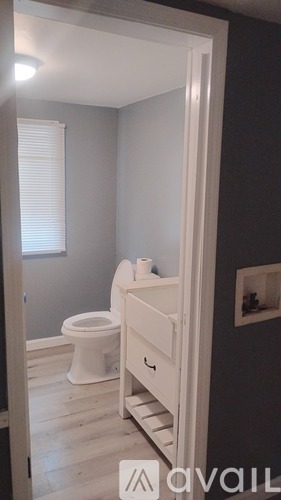 A white toilet sits in a bathroom with a white door.
