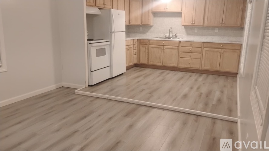 A kitchen with wooden floors and white appliances.