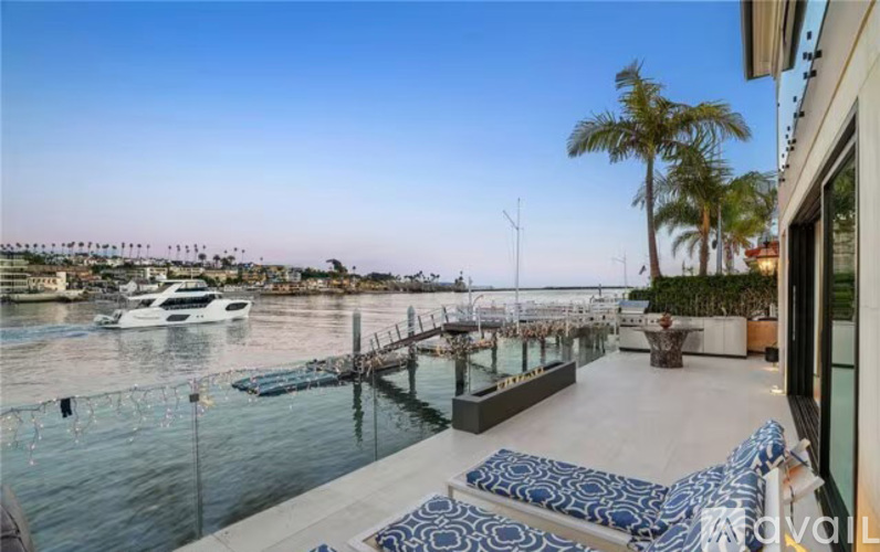 A balcony overlooks a marina with boats and palm trees.