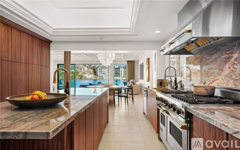 A modern kitchen with wooden cabinets and a marble countertop.