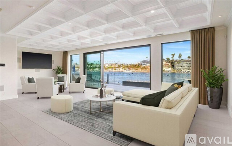 A spacious living room with a large couch and a flat-screen TV.