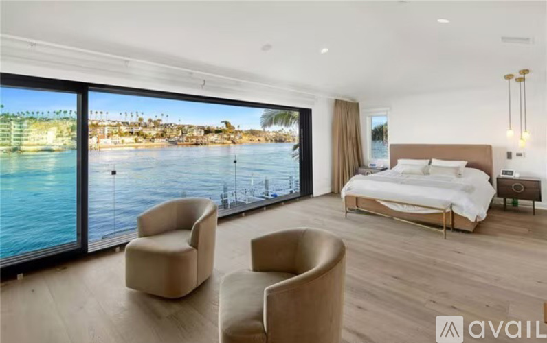 A bedroom with a large bed and a view of the water.