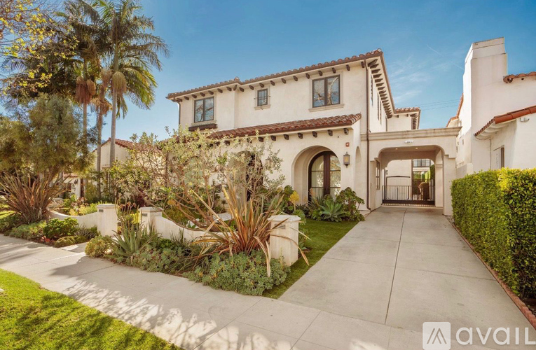 A large house with a driveway and a garden in front.