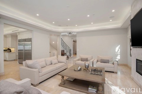 A modern living room with a white sofa set and a wooden coffee table.