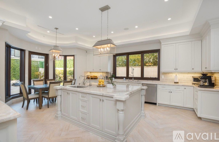 A modern kitchen with white cabinets and a large island.