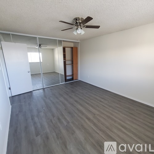 A room with a ceiling fan and a sliding glass door.