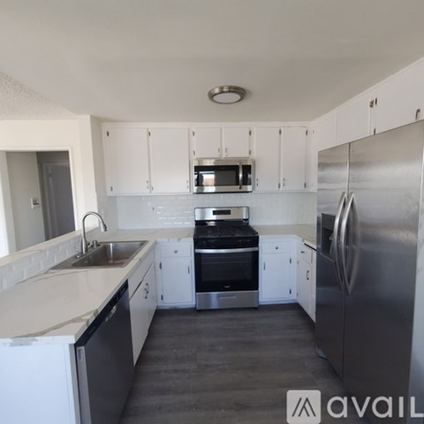 A kitchen with white cabinets and stainless steel appliances.