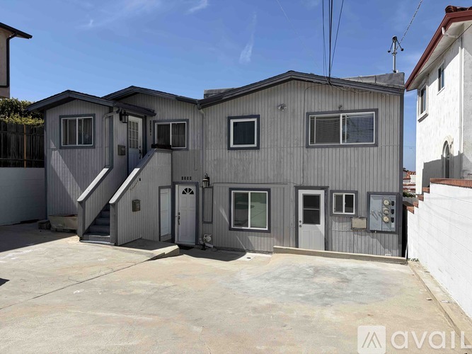 A grey two-story house with a garage and a driveway.