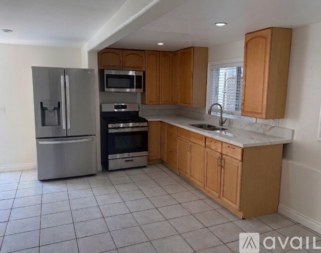 A kitchen with wooden cabinets and a stainless steel refrigerator.