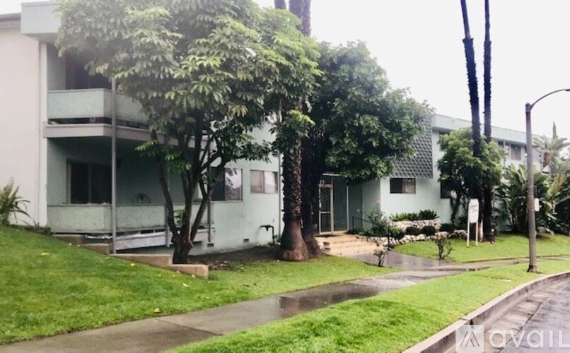 A tree in front of a white building.