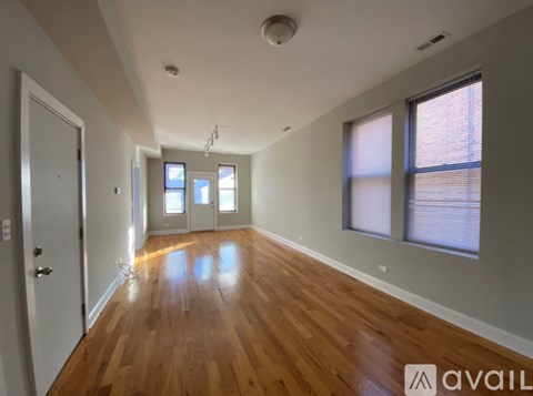 A spacious room with wooden floors and white walls.