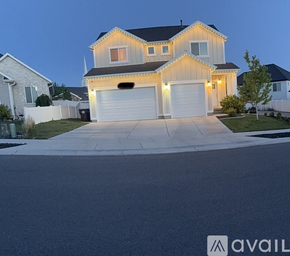A house with a garage is lit up at dusk.