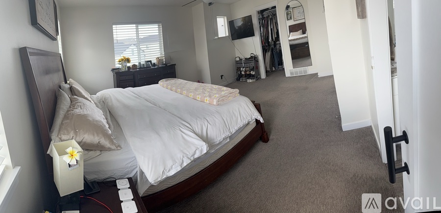 A bedroom with a large bed and a TV in the corner.