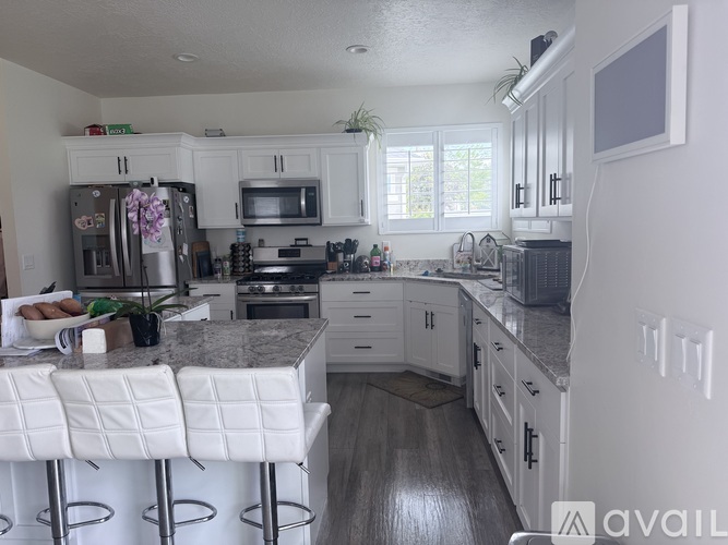 A kitchen with white cabinets and a granite countertop.