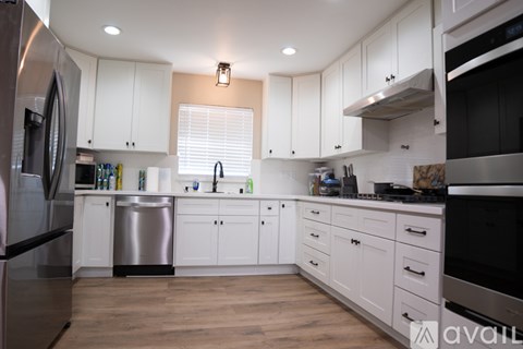 A kitchen with white cabinets and stainless steel appliances.