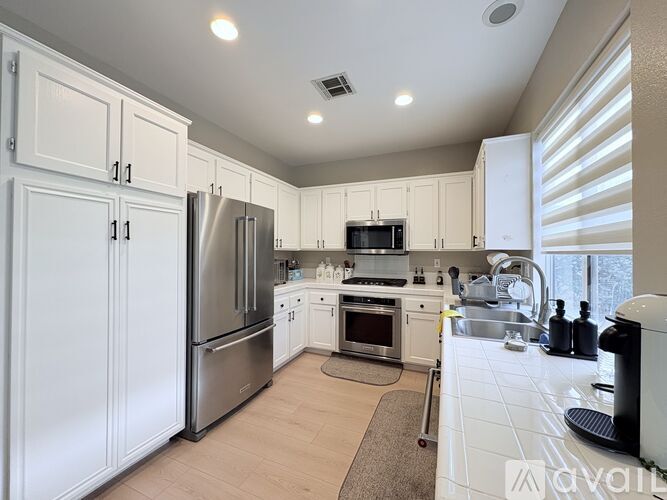 A kitchen with white cabinets and stainless steel appliances.