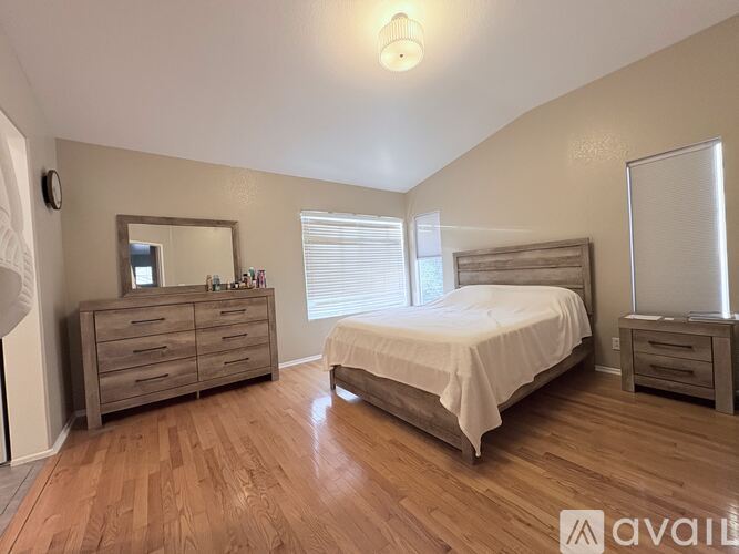 A bedroom with a bed, dresser, and mirror.