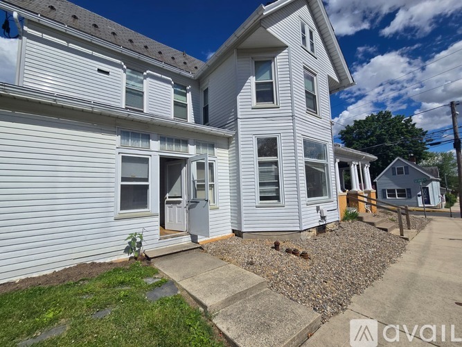 A two-story house with a grey exterior and a small front yard.