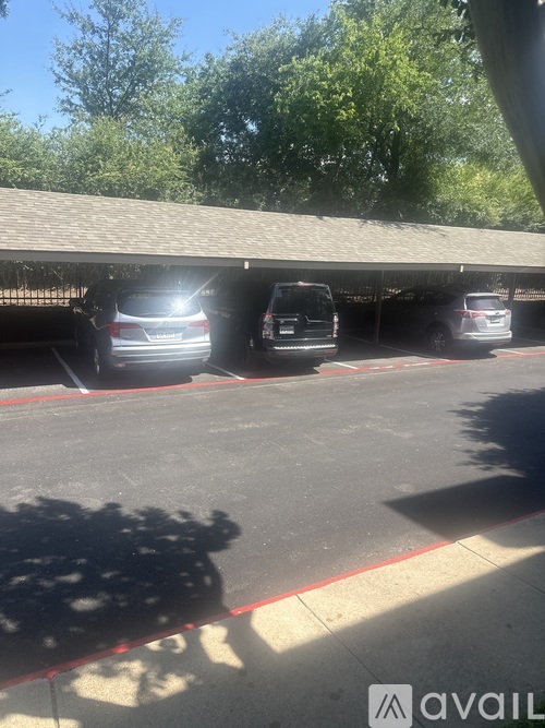 A parking garage with three cars parked in it.