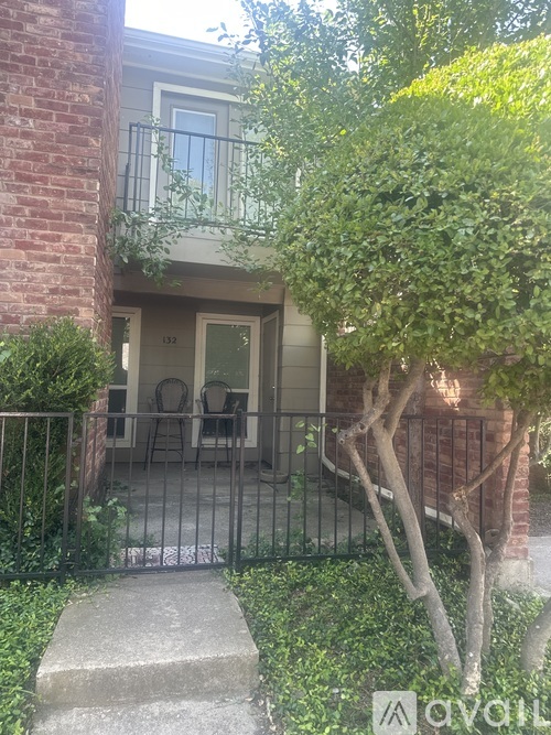A small tree is in front of a house.