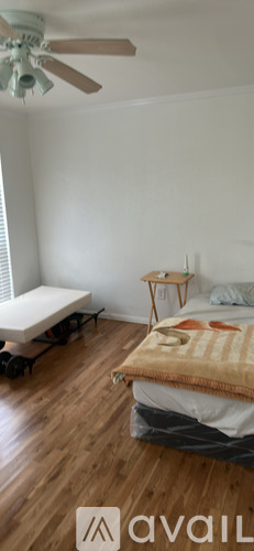 A bedroom with a bed, a chair, and a window.