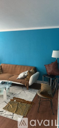 A living room with a brown couch and a white chair.