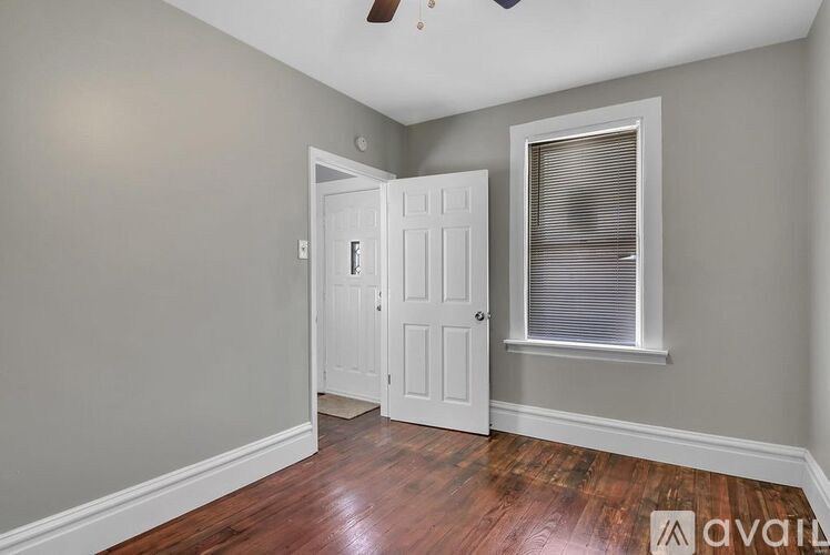 A room with a white door and a window with blinds.