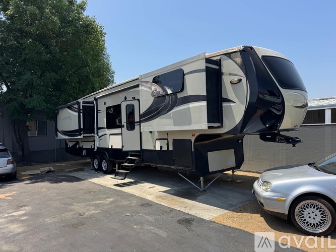 A large, modern RV is parked in a lot.