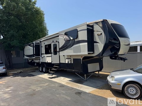 A large, modern RV is parked in a lot.