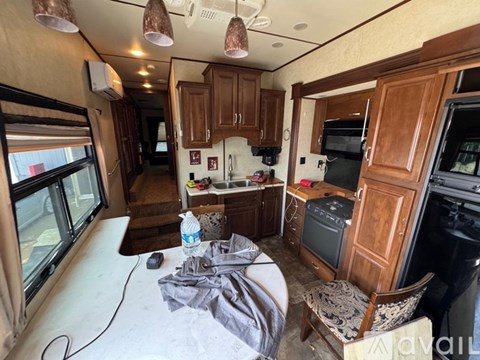 A kitchen area with wooden cabinets and a microwave.