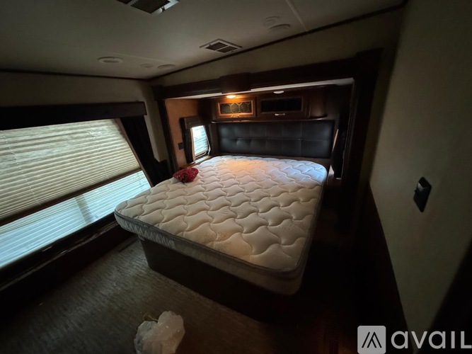 A bedroom with a bed, a window with blinds, and a ceiling fan.