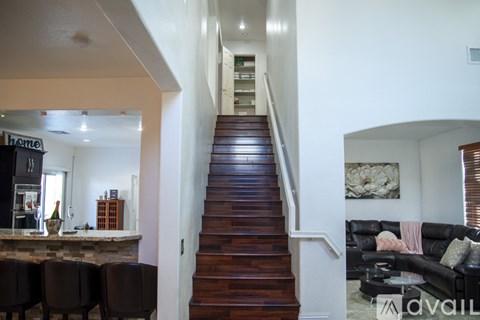 A living room with a couch and a staircase.