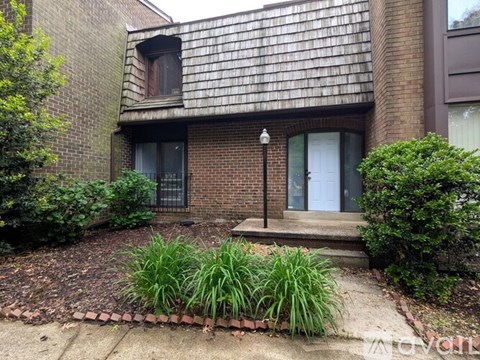 A small house with a brick facade and a white door.